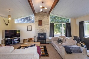 Ein Wohnzimmer mit Kamin, Fernseher und einer Couch.