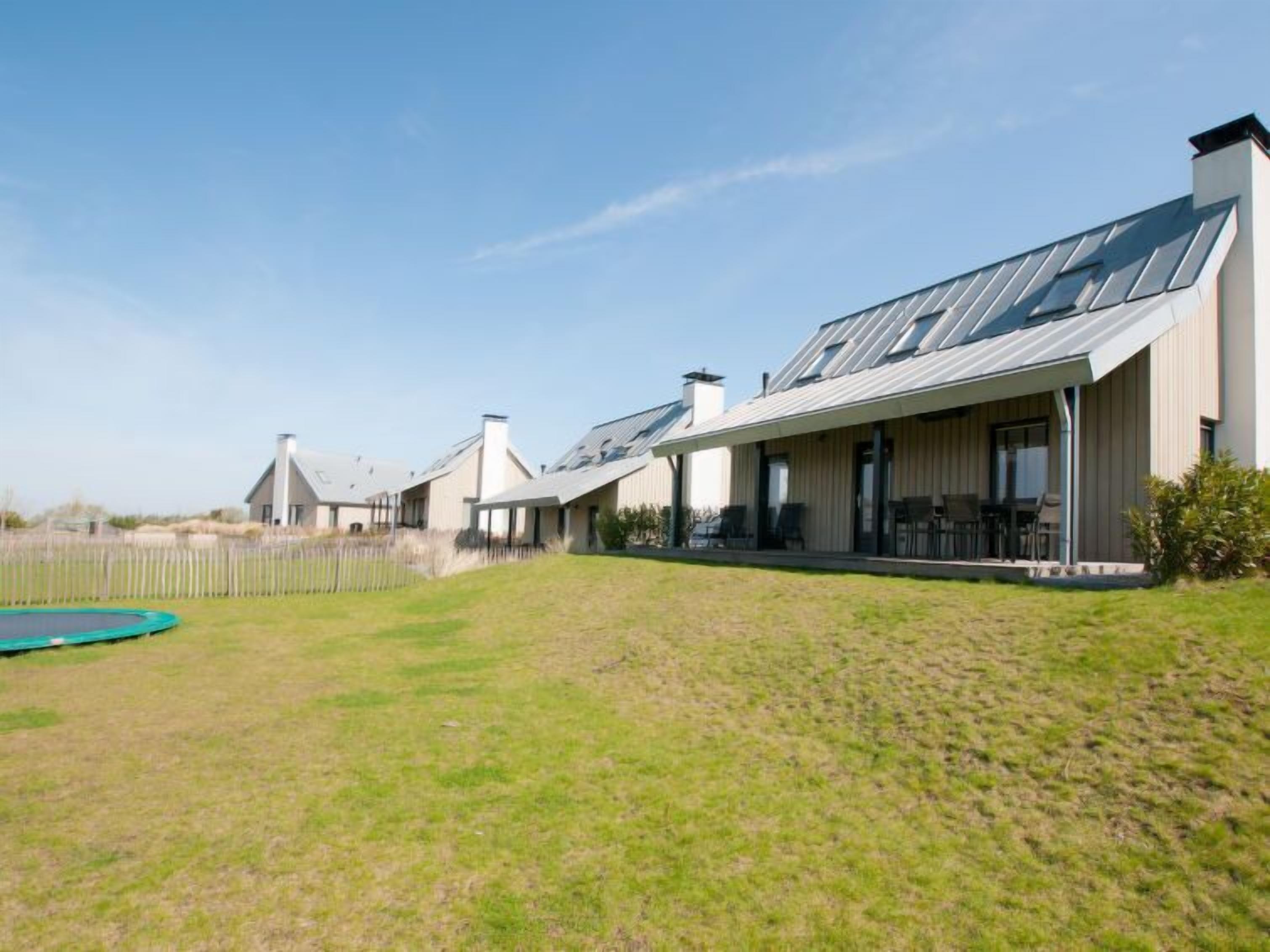 Een modern woongebouw met een overdekt terras en een zwembad.