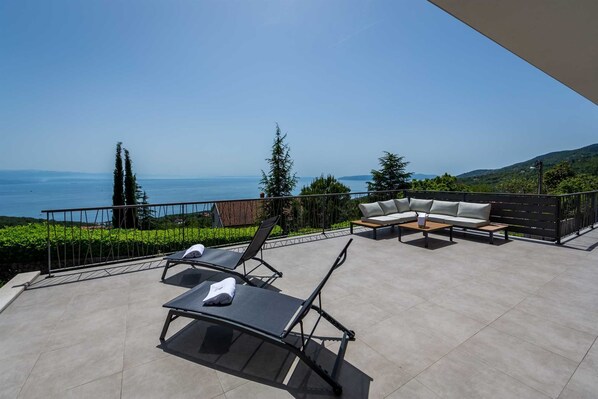 Una terraza con vistas al mar, que incluye sillones y un sofá.