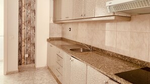 A kitchen with granite countertops, a stainless steel sink, and a built-in oven. - A&F Comfort Modern House (Santa Lucía de Tirajana)