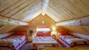 Un dormitorio acogedor en el ático con dos camas, vigas de madera y una ventana con cortina roja.