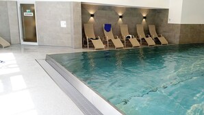 A swimming pool with lounge chairs and a door marked "AUSGANG". - Modern furnishings, balcony. wonderful mountain view summer - mountain railway ticket inc. (Mittelberg)