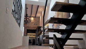 A modern interior with a staircase, a chandelier, and a kitchen area. - Luxurious apartment in historic building  downtown Puebla SV311 -12 (PUEBLA)