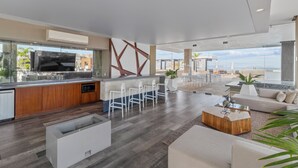 Une cuisine moderne avec un coin bar, de grandes fenêtres et une vue sur la plage.