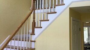 Una escalera de madera con balaustres blancos y una plataforma.