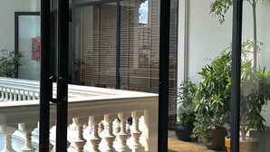 Ein Hotelzimmer mit Blick auf einen Balkon, einen Pool und die Skyline der Stadt.