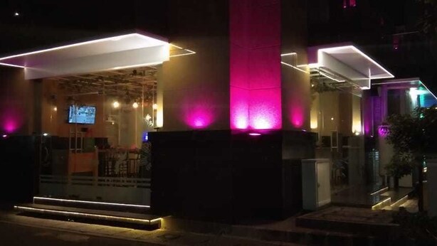 A hotel entrance with a modern design, featuring a prominent entrance with steps leading up to a covered area. - An Hotel Satrio Kuningan (Jakarta)