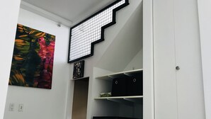 A modern interior with a staircase, a painting, and storage bins labeled "WHITES" and "NON-WHITES".