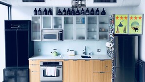 A modern kitchen with stainless steel appliances, wooden cabinets, and a variety of decorative items on the wall.