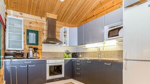 Eine moderne Küche mit grauen Schränken, einem Edelstahlbackofen und einer Mikrowelle.