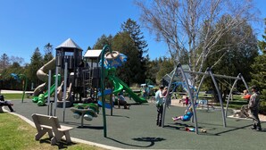 A playground with slides, climbing structures, and swings. - Waterfront Home In Baileys Harbor ~ Fantastic Views Of The Harbor And Islands! (Baileys Harbor)