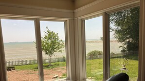 A room with large windows overlooking a grassy area and a body of water. - Waterfront Home In Baileys Harbor ~ Fantastic Views Of The Harbor And Islands! (Baileys Harbor)