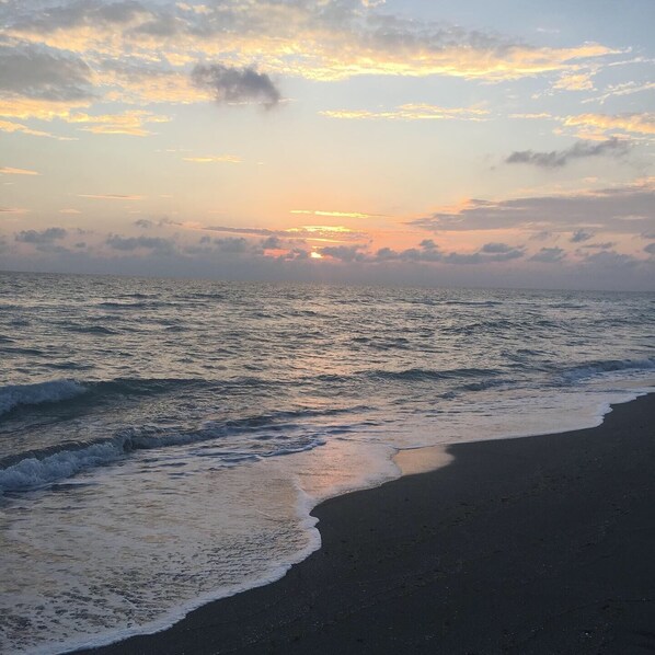 A beach with waves at sunset.