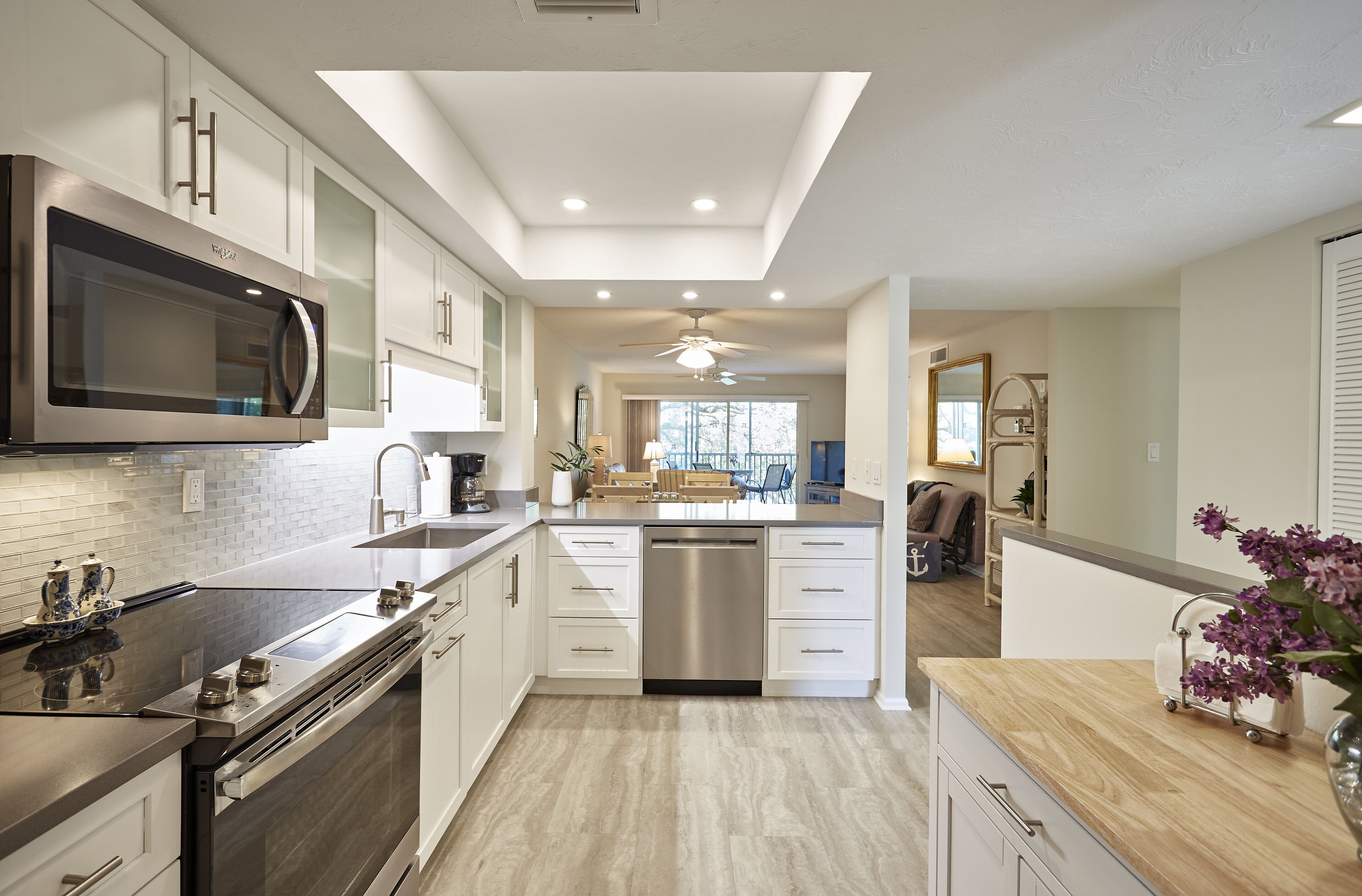 A modern kitchen with a central island, stainless steel appliances, and a ceiling fan.