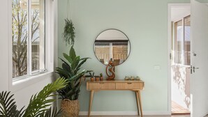 Une pièce comprenant une console en bois, un miroir et diverses plantes en pot.