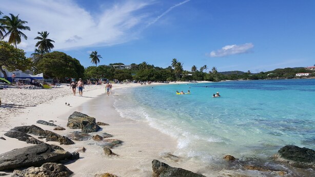 A beach with clear turquoise water, white sand, and rocky outcrops. - Scenic Ocean front walk-out~fully renovated~property wide generators  (St Thomas, USVI)