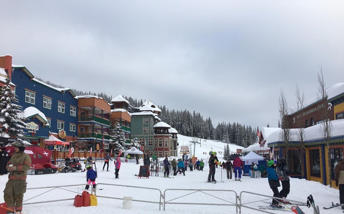 A snowy ski resort with colorful buildings and a ski slope.