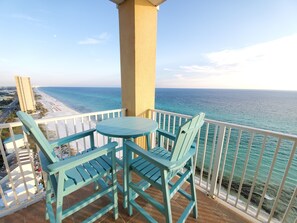 Ein Balkon mit Blick auf Strand und Meer.