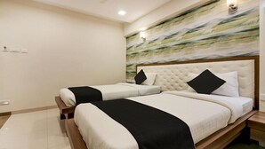 Une chambre d’hôtel avec deux lits, un sol en marbre, une grande peinture abstraite au mur et une tête de lit en bois.