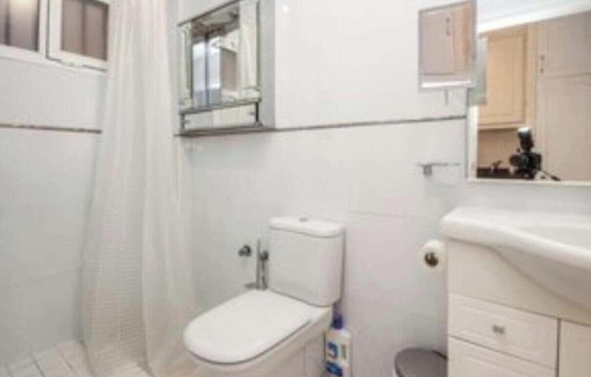 Ein Badezimmer mit Toilette, Waschbecken und Spiegel.