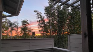 A covered outdoor seating area with two chairs and a view of a sunset. - Coastal Studio Retreat!! WALK TO SURF & SAND or 1 MIN DRIVE!!! GREAT LOCATION!!! (Carlsbad)