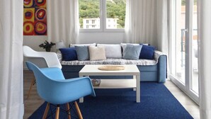 Ein modernes Wohnzimmer mit einer Couch, einem Couchtisch und einem blauen Sessel.
