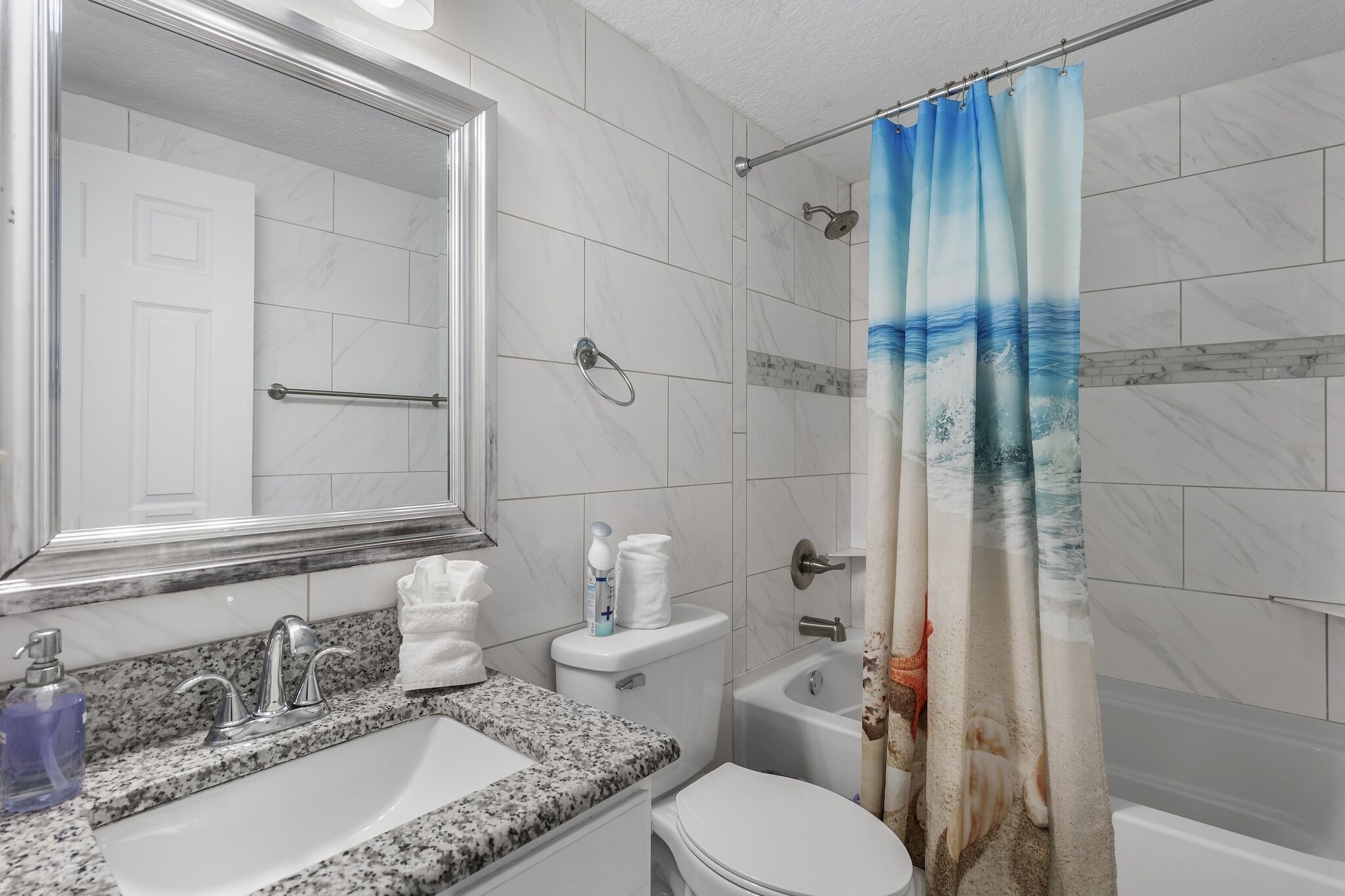 A bathroom with a sink, toilet, and shower.
