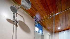 Une salle de bain moderne dotée d’une douche à parois de verre, de toilettes et d’un lavabo.