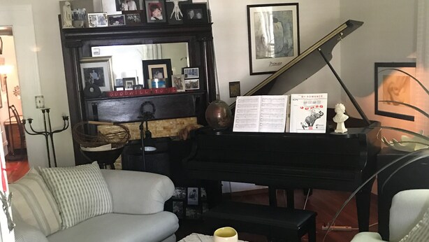 A living room with a grand piano, a sofa, a coffee table, and a fireplace. - The Zen-ter BNB Suite #1 in the Heart of Carrollton Georgia (Carrollton)