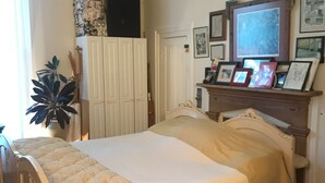A bedroom with a bed, a dresser, a ceiling fan, and a wall with framed pictures. - The Zen-ter BNB Suite #1 in the Heart of Carrollton Georgia (Carrollton)