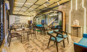 A modern hotel lobby with a central seating area, a staircase, and a reception desk. - hotel Metropole Inn (Mumbai)