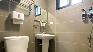 A bathroom with a toilet, sink, and hand dryer. - Adagio Hostel (Taichung)