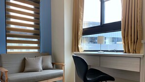 A modern room with a sofa, a desk, and a chair. - Adagio Hostel (Taichung)