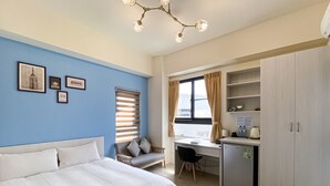 A bedroom with a bed, a desk, a chair, and a wardrobe. - Adagio Hostel (Taichung)