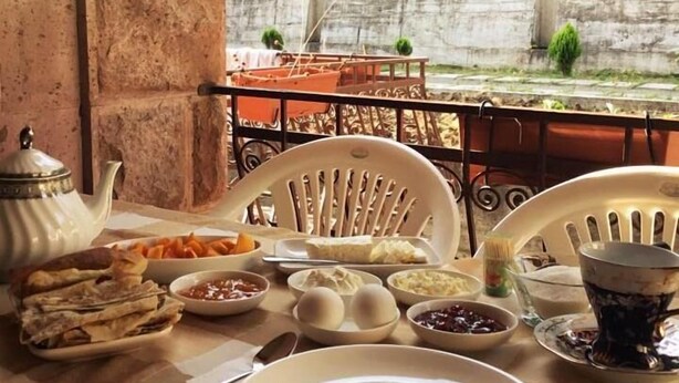 A table set with various dishes, a teapot, and a cup, likely for a meal. - Seva Guesthouse in Byurakan (Byurakan)