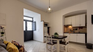 Una cocina moderna con armarios blancos, encimera negra y una lámpara colgante.