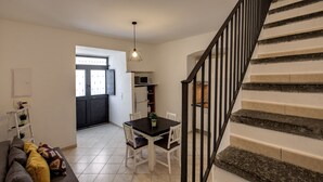 Un interior moderno con una escalera, un comedor y una cocina.