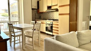 Una cuina moderna amb armaris de fusta, una taula de dinar i cadires.