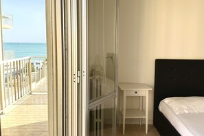 A room with a bed, a desk, and a view of the ocean. - M223 - Marcelli, three-room apartment in the center and facing the sea (Marcelli)