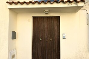 Une porte en bois fermée, dotée d’une poignée en métal, d’un coffre-fort et d’une petite pancarte fixée au mur.