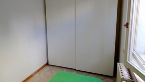Et værelse med en grøn måtte, et hvidt skab og en radiator.