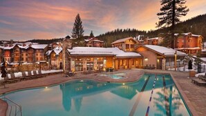 Un resort con una gran piscina, varias construcciones y un paisaje nevado.