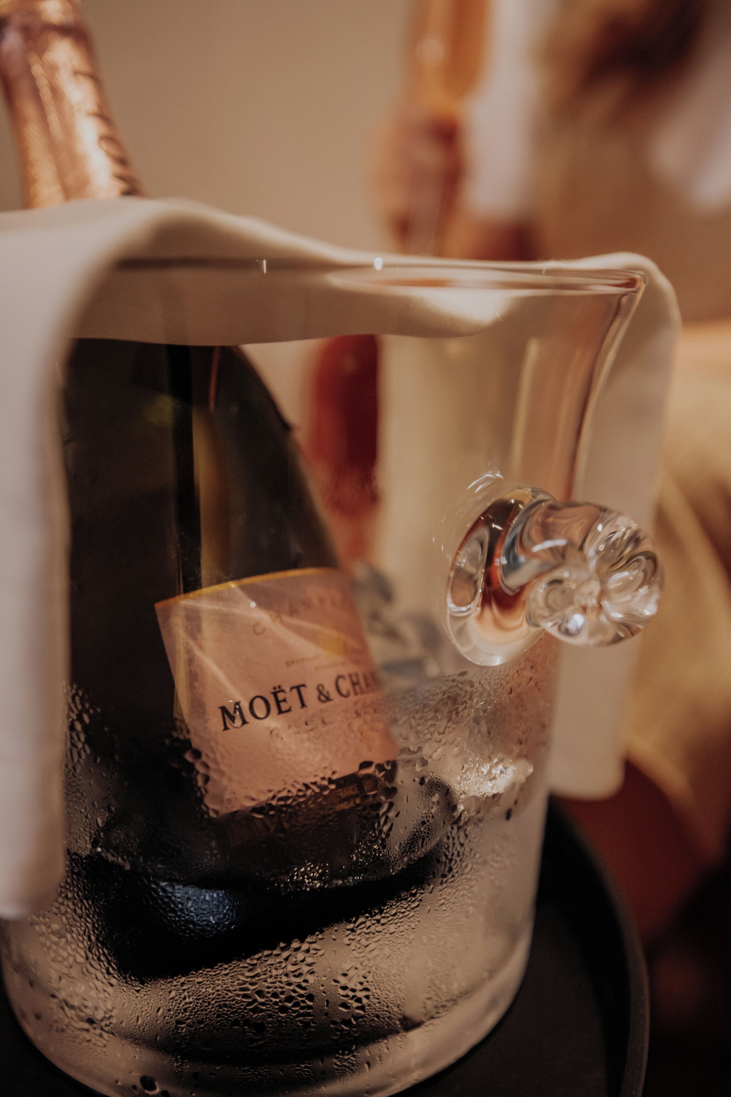 En glaskaraff med en kork och en etikett med texten ”MOËT & CHANDON” står på ett bord.