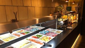Un bufé con diversas opciones de comida y una zona de bar con bebidas.