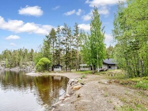 Une propriété au bord du lac comprenant un chalet, un quai et un petit bâtiment.