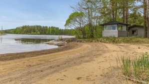 A lakeside cabin with a sandy beach and forested area. - Wuorilahti by Interhome (Savonlinna)