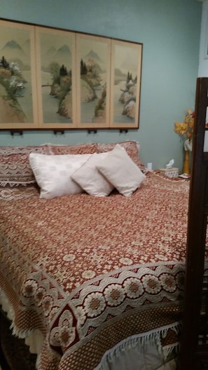 Cozy retreat with a large bed and a beautiful landscape artwork above.