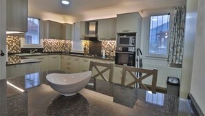 Una cucina moderna con piani di lavoro in granito, un'isola centrale e un forno a microonde.