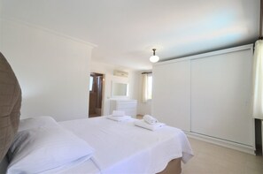 Relax in a serene space with a neatly made bed, dresser, and wardrobe.