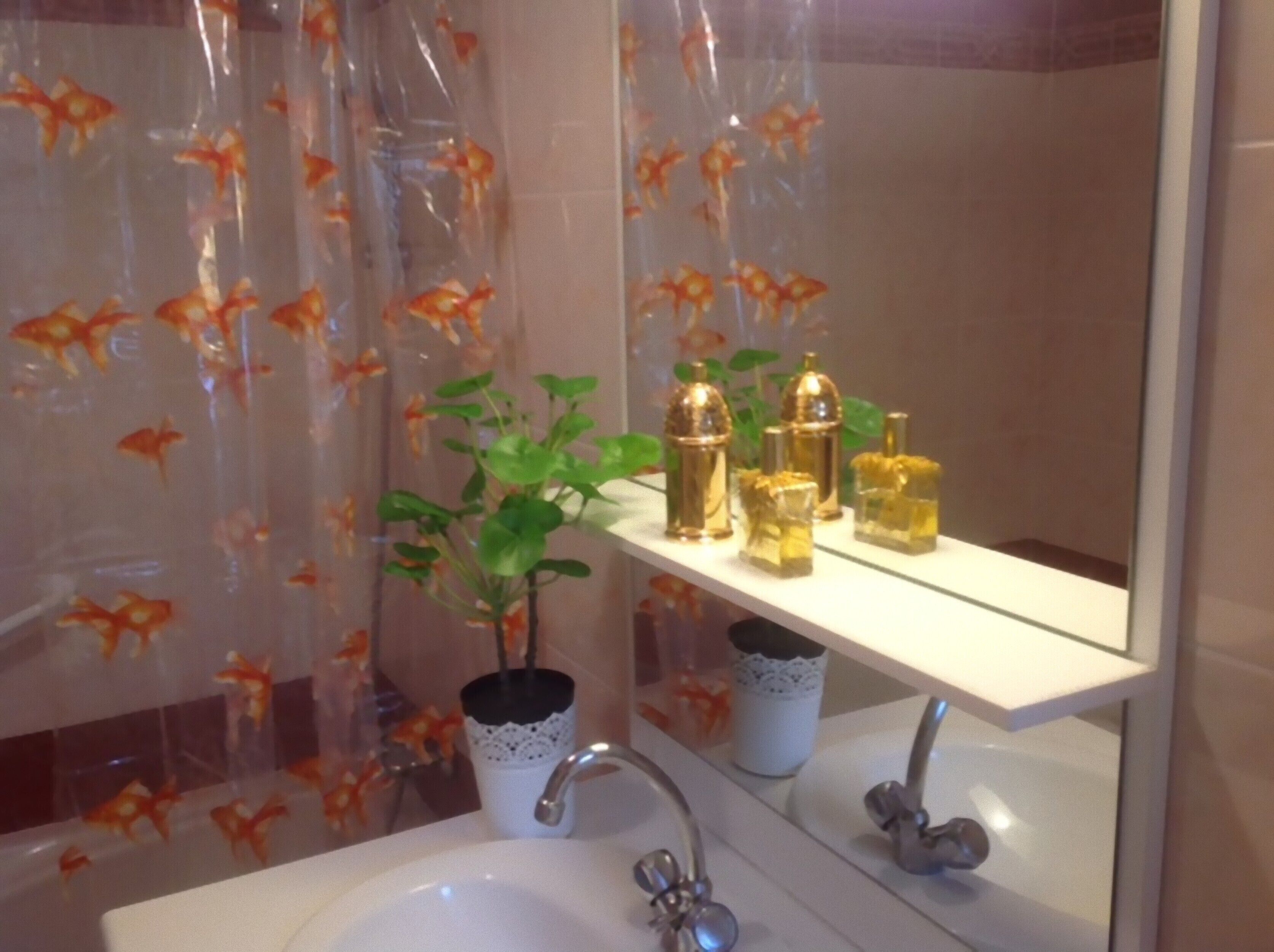 Een badkamer met een wastafel, spiegel en plank met toiletartikelen.